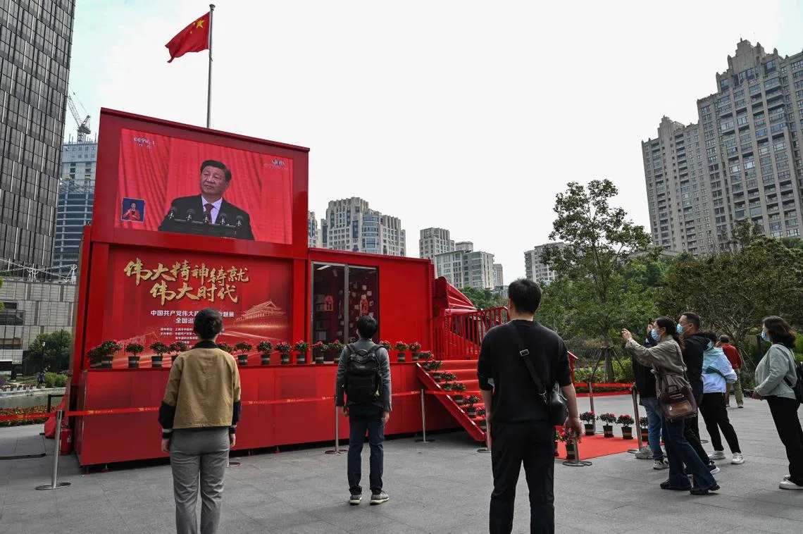 中国民众在上海街头观看中国国家主席习近平在中国共产党第二十次全国代表大会（中共二十大）发表工作报告。（法新社）