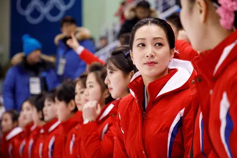 朝鲜拉拉队员身着红色统一服装亮相观众席，在10日的冬奥会冰球比赛中为韩朝女子冰球联队加油助威。（法新社）