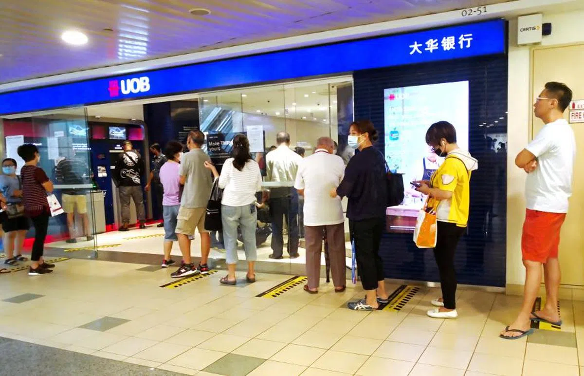 本地银行相继推出诱人的定存利率，吸引不少民众前去排队存钱。（联合早报）