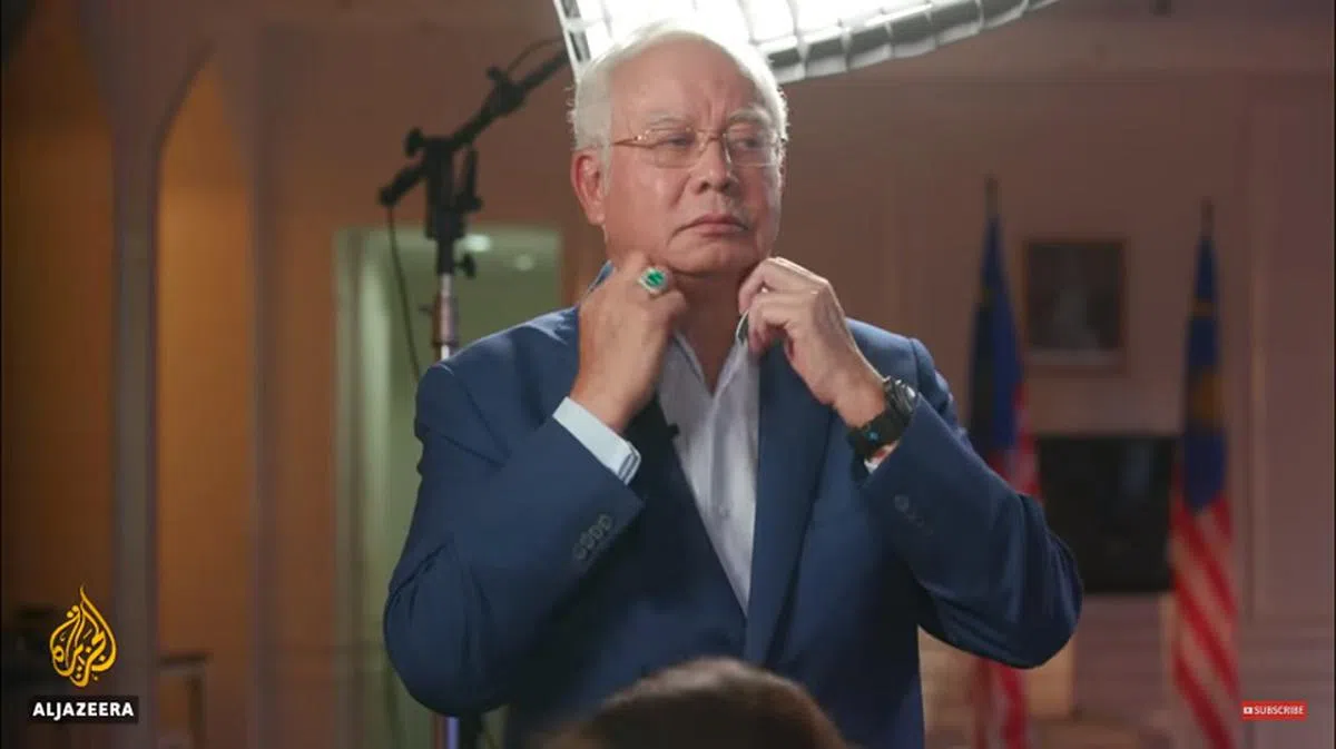  不满主持人揪着一马案的问题紧咬不放，纳吉愤怒地站起身整理衣服准备离开。（视频截图） 