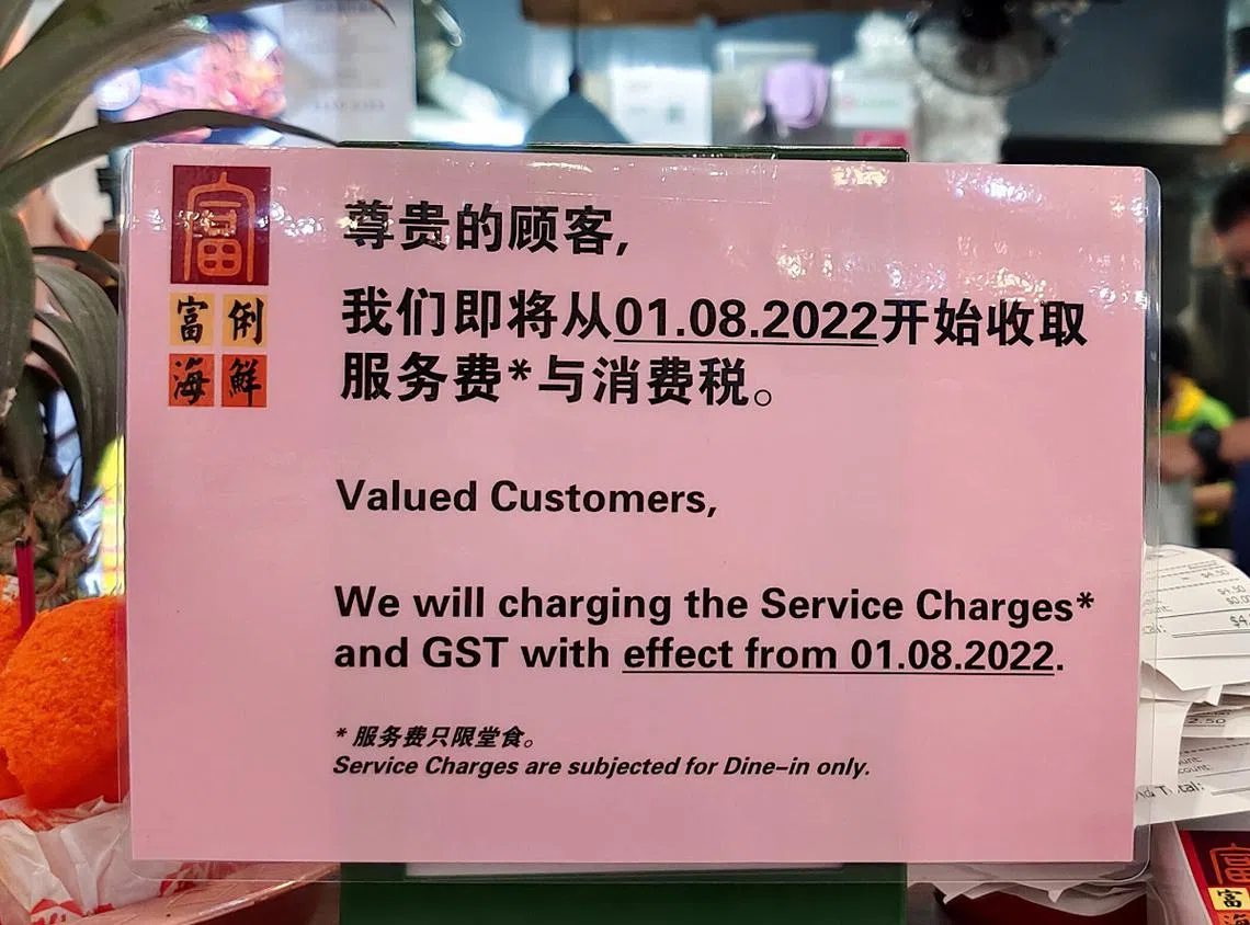 富俐海鲜摊位近日在碧山12街第120座组屋咖啡店分行前，张贴一张告示通知顾客，指即将从8月1日起，开始收取服务费与消费税。（新明日报）