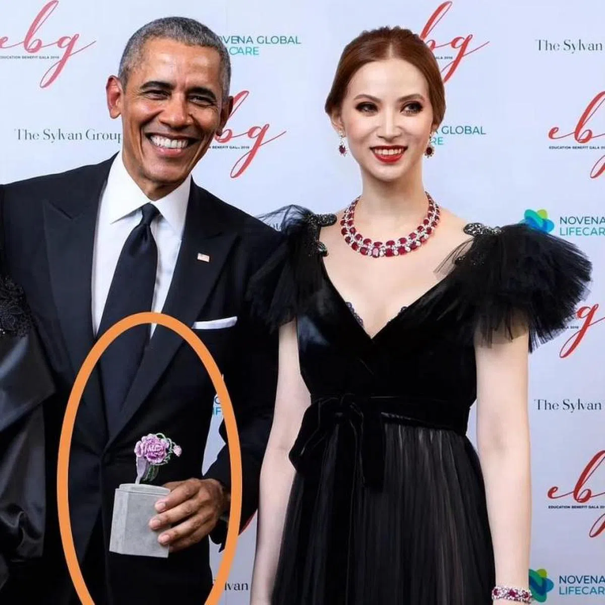  沈屮（右）去年12月主持奥巴马基金会青年领袖论坛与慈善拍卖会时，戴上了贝拉格夫珠宝的300卡拉红宝石项链。奥巴马手中握着的就是沈屮送给奥巴马夫人米歇尔的手镯，也是贝拉格夫珠宝出品。（贝拉格夫珠宝面簿） 