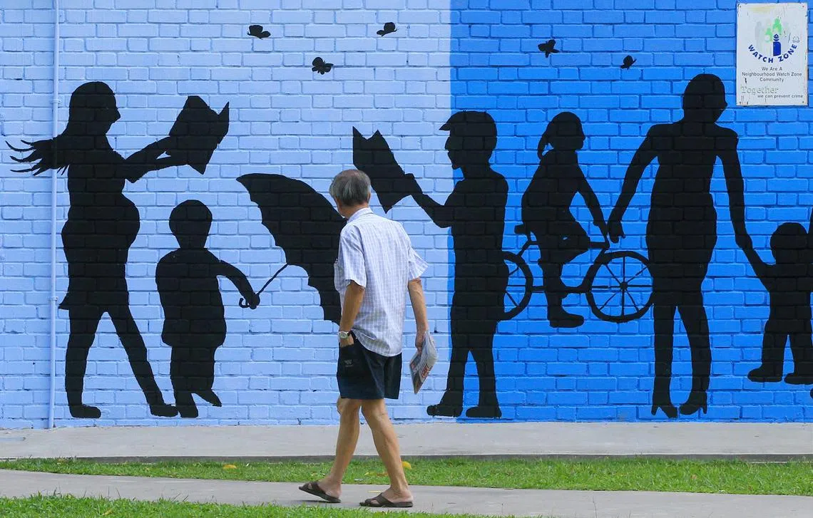 2012年，大巴窑8巷第213座组屋楼下的墙壁上，画着一个个人形剪影，代表着年轻人温馨美满的家庭世界，与恰巧单独路过的年长者形成对比。（联合早报）