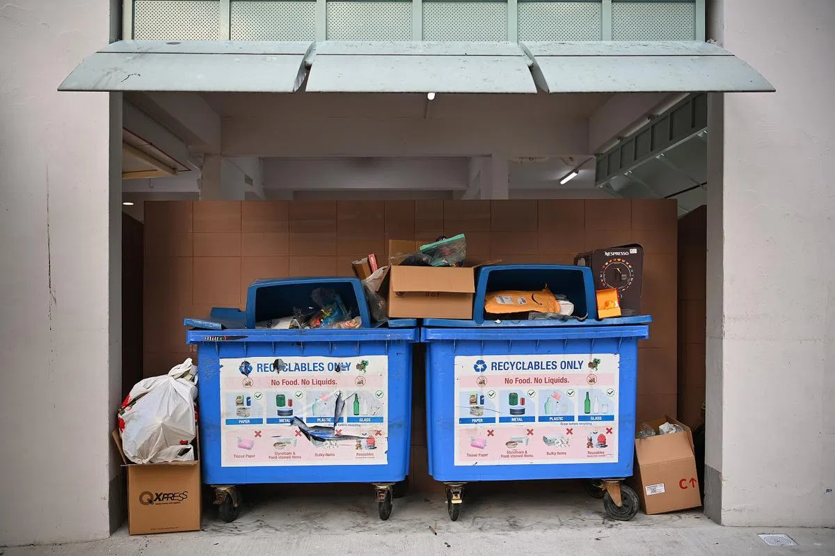 一些民众把不可回收的垃圾，丢入组屋底层的大型蓝色回收桶，俨然成了垃圾站。（海峡时报）