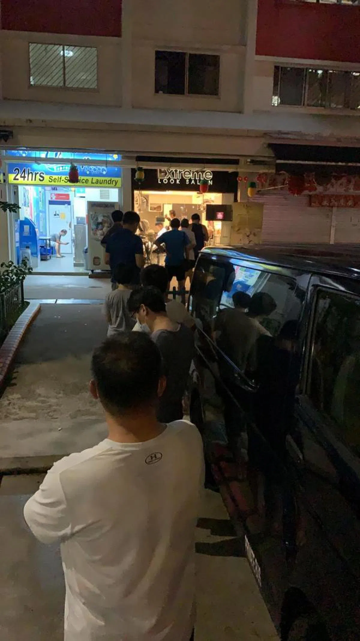  某组屋区内排队等候理发的男生，红蚂蚁的小伙伴说男生如果超过一个月不理发就会顶着一头杂草。（蚁粉提供） 