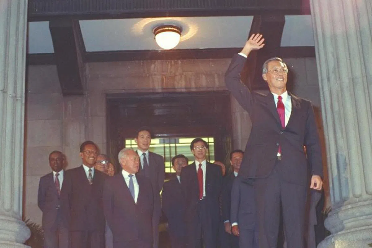  1990年11月28日，吴作栋（右一）宣誓成为新加坡第二任总理后，对着政府大厦草场上的人群挥手。在他身后的是当时的内阁成员。（海峡时报） 