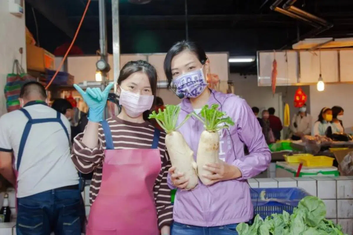 新竹市长候选人高虹安（右）拿着“菜头”摆拍。（桃园电子报）