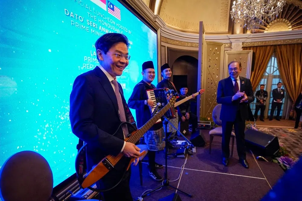 黄循财总理在马来西亚首相安华为他举办的午餐会上，受邀上台弹手吉他。