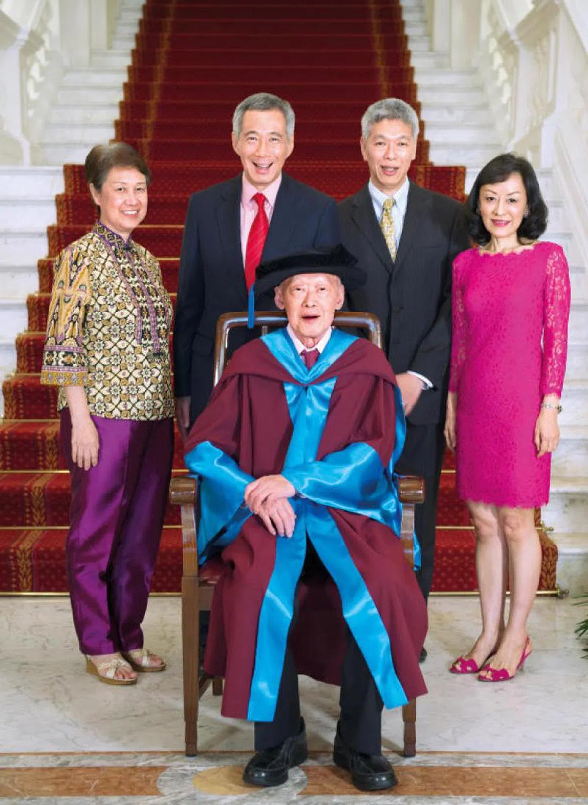  李光耀2013年获颁新加坡国立大学名誉法学博士学位时，与家人一起合照。站立者左起：李显龙夫人何晶、李显龙总理、李显扬与妻子林学芬。（海峡时报） 