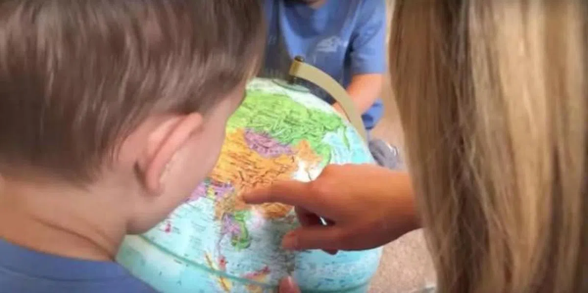  2016年五月份，Becca指着地球仪告诉两名儿子，爸爸妈妈要到中国接一个妹妹回来，他们马上就要成为哥哥啦！（Becca的Instagram） 