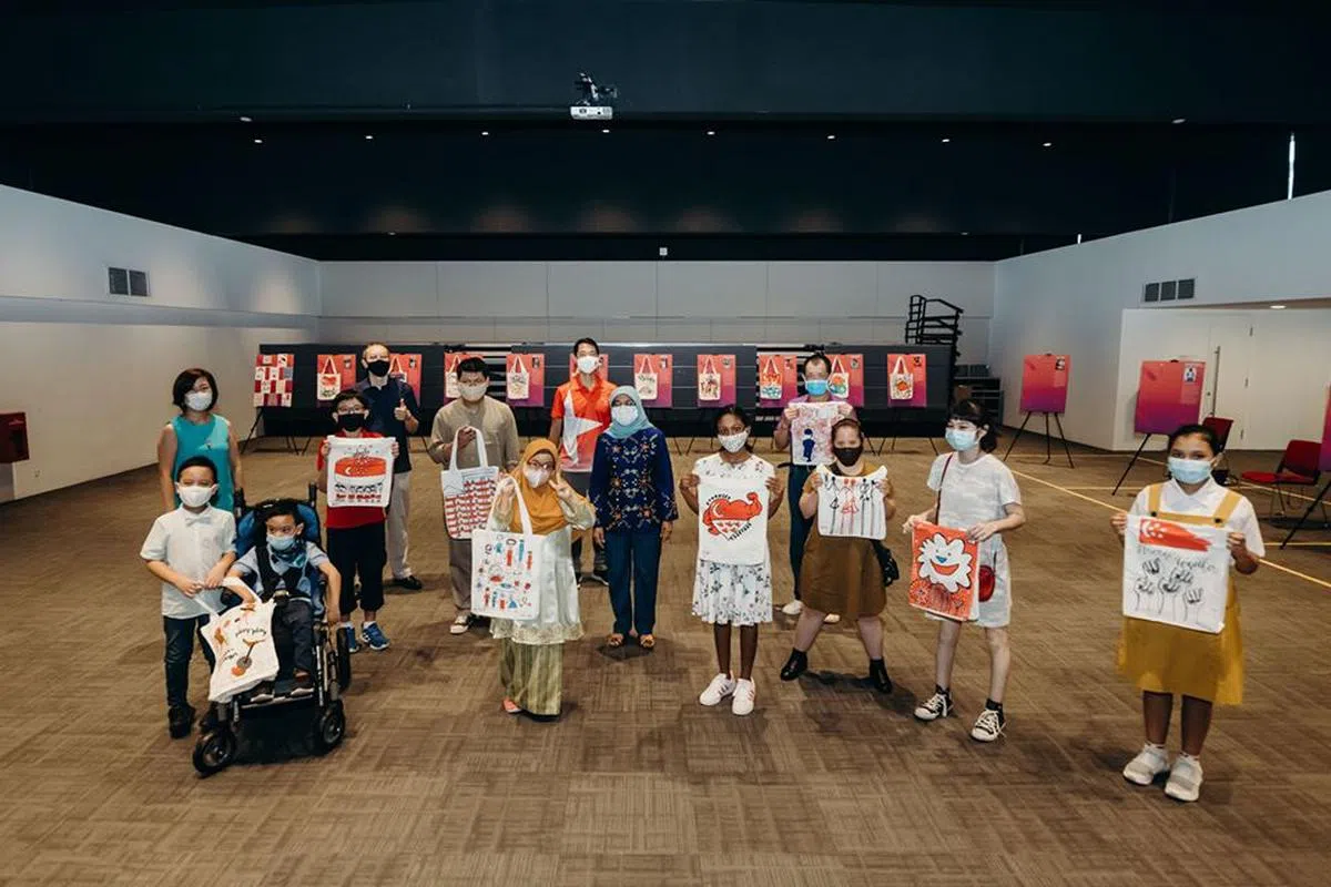  哈莉玛总统（中）和国庆礼包设计者合影，他们包括特需人士以及小学五年级学生。（黄永宏面簿） 