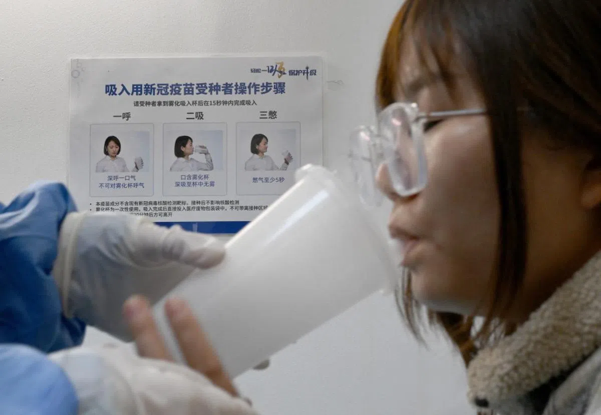 北京一名女性接种吸入式疫苗。（路透社）