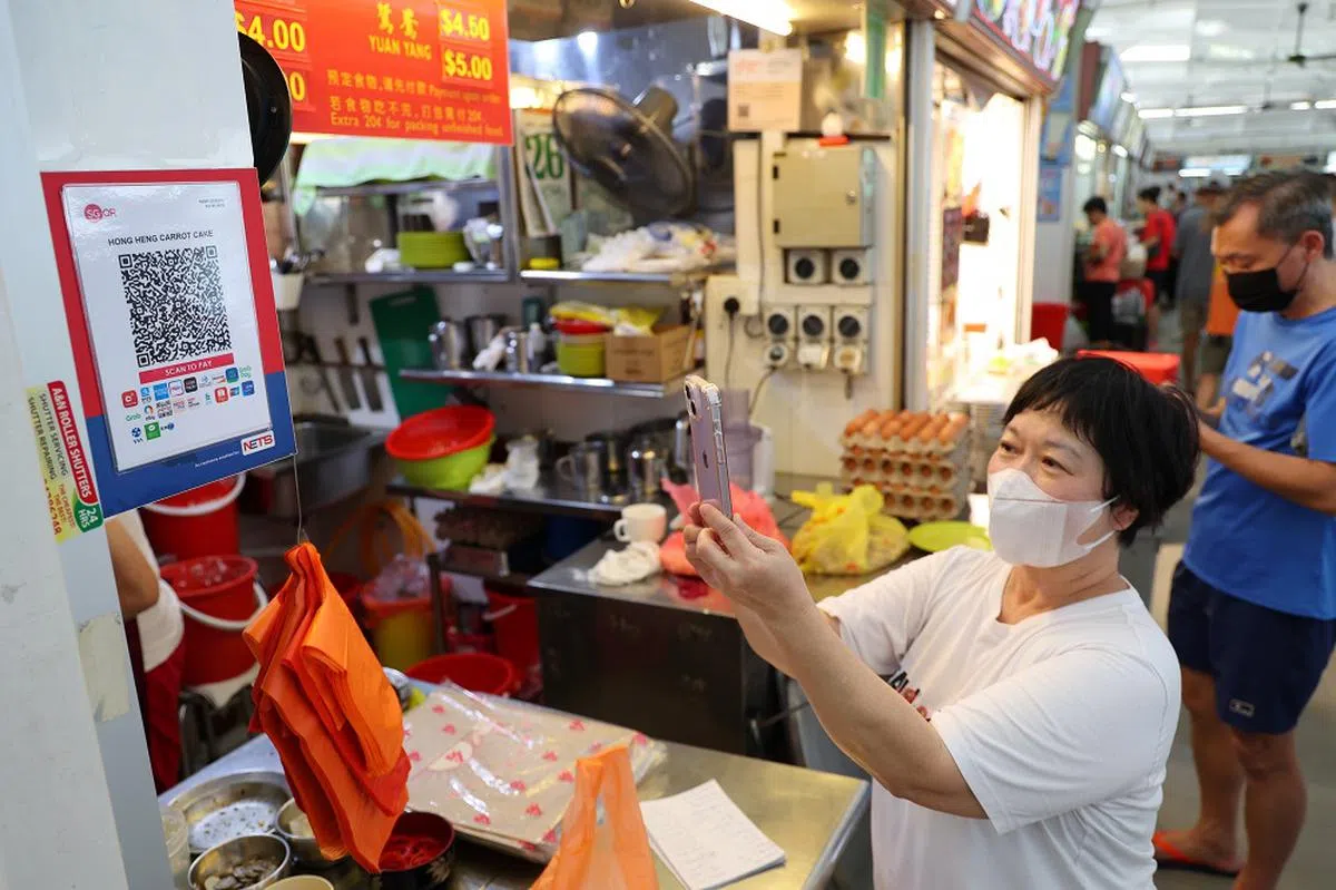 扫码付款，速战速决，小贩和食客都省时省力。（联合早报）