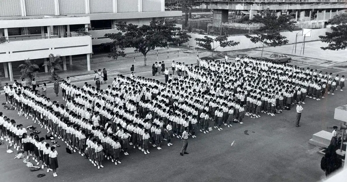  华义中学在1985年举行升旗礼的情况。（档案照） 