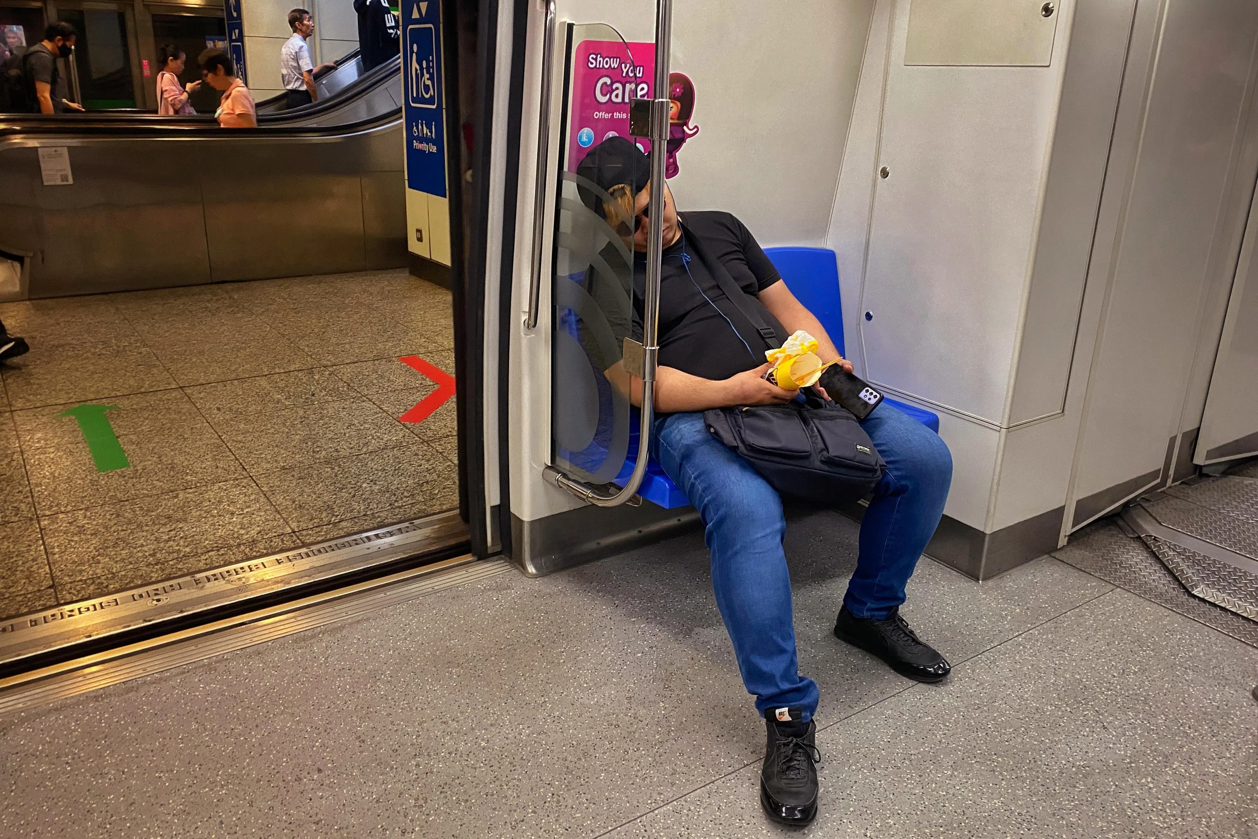 在新加坡地铁上岔开腿坐（manspreading）。