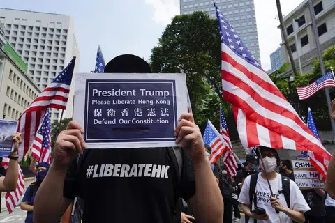 香港示威者高举特朗普总统请解放香港的牌子，后面的示威者则高举美国星条旗。（互联网）
