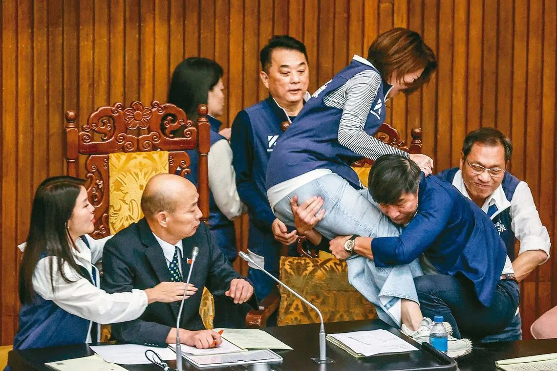 台湾民进党立委钟佳滨（右二）一把扑倒国民党籍立委陈菁徽。（取自X）