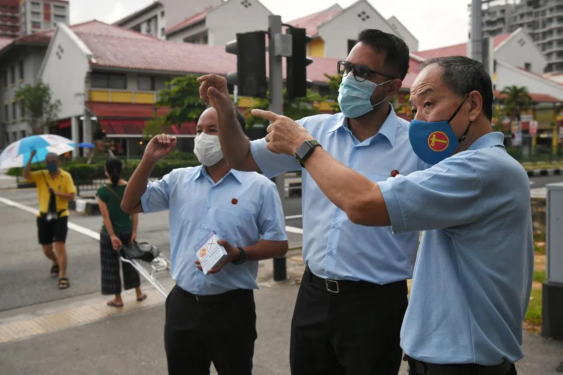 刘程强（右）在2020年大选中为工人党阿裕尼集选区团队的毕丹星（中）及费沙（左）拉票。（海峡时报）