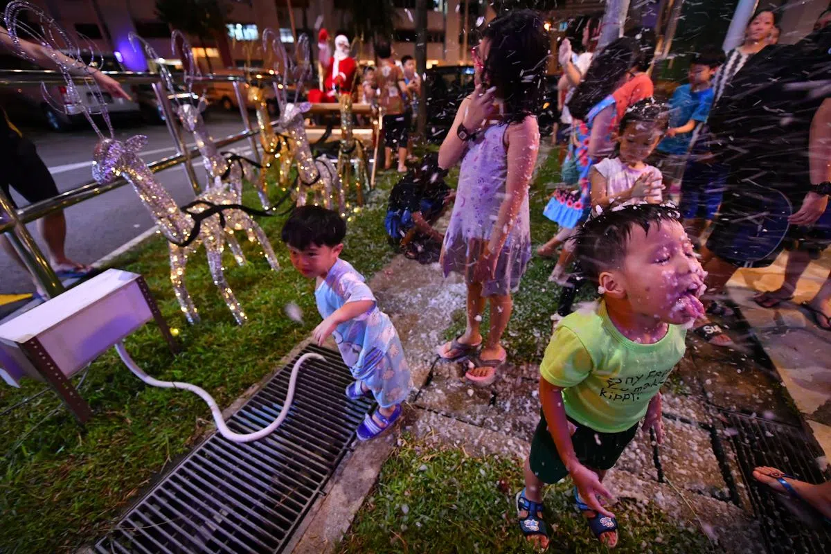  兀兰13街一带的小孩儿在陈先生制作的人造雪陪伴下，欢声笑语，乐此不彼。（海峡时报） 