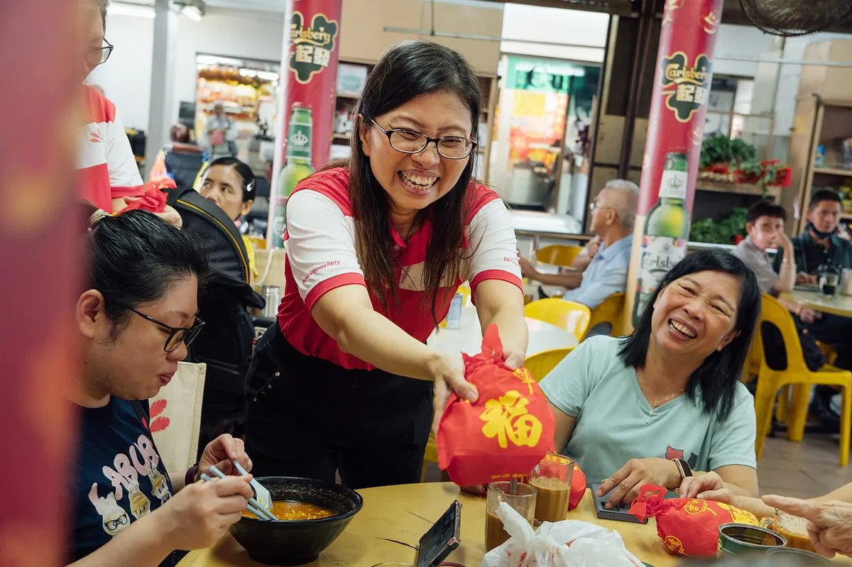 潘群勤和团队每周都走访西部选区，图为她2025年农历新年为居民派福袋。（新明日报）