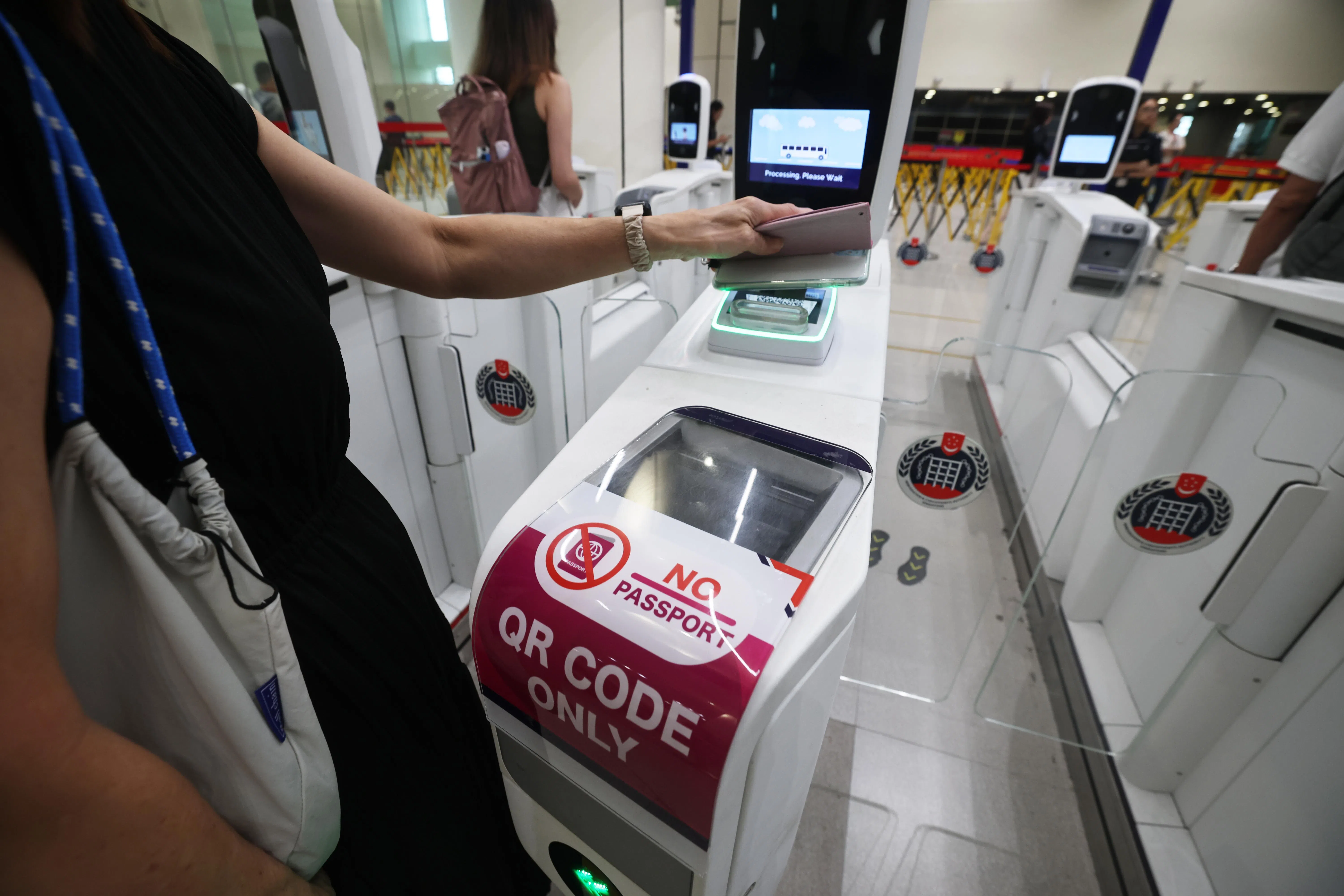 QR码等自动通关设施让当局能有更多人力辨识可疑旅客。