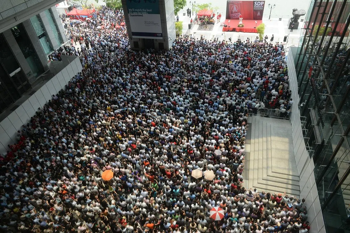 2015年大选新加坡民主党中午时分在中央商业区大华银行大厦旁举行群众大会，吸引了大批公众围观。（联合晚报）