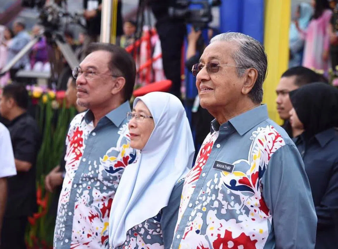 马哈迪（右）、安华（左）和旺阿兹莎（中）31日出席马国国庆庆典。（安华面簿）