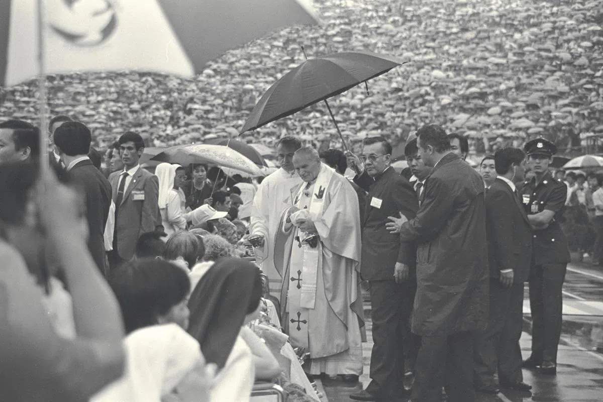已故教宗约翰保罗二世1986年11月20日，在雨中于新加坡国家体育场为7万人主持一场弥撒。（海峡时报）