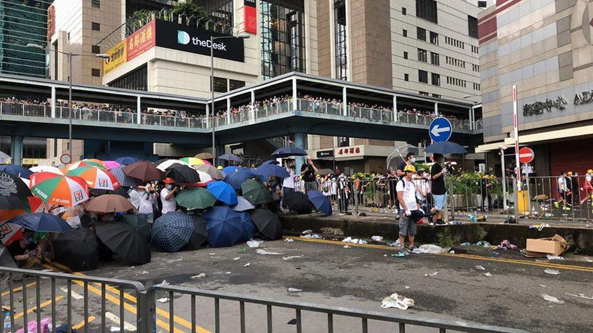  抗议群众使用雨伞阻挡警方的催泪弹攻势。（立场新闻） 