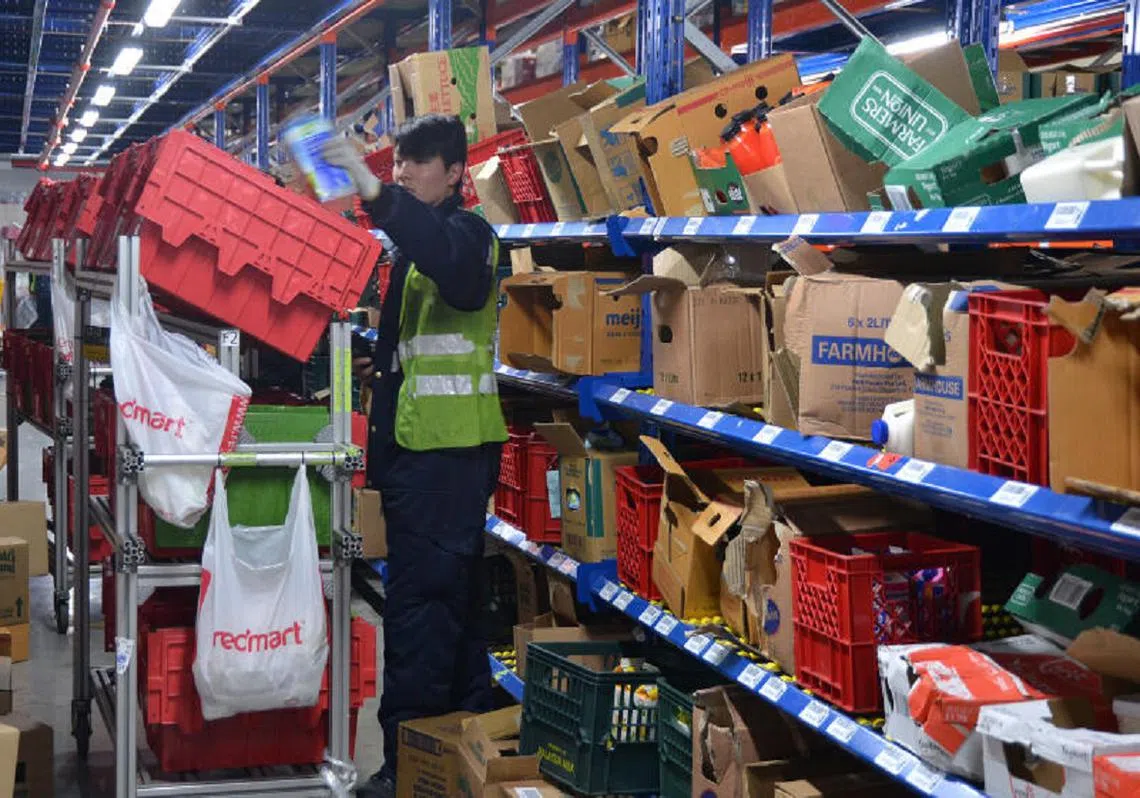 RedMart员工接收到数量暴涨的订单在仓库里辛勤工作。（海峡时报）