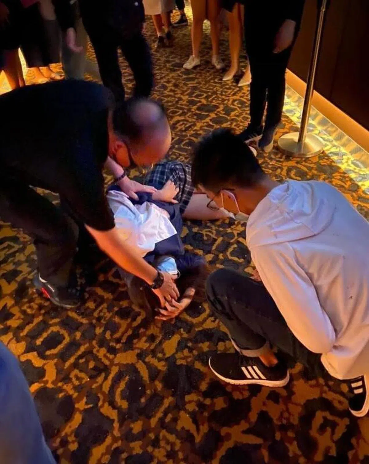  一名伤者走出电影院后，瘫倒在外头的走廊上。（互联网） 