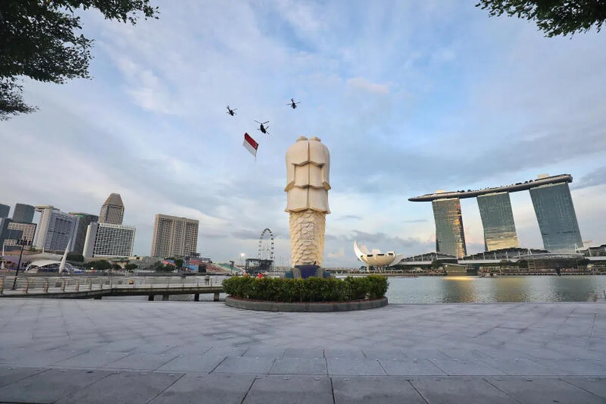 2021年新加坡国庆庆典于8月21日在海湾浮动舞台举行，悬挂着巨型国旗的直升机飞越上空。（联合早报）