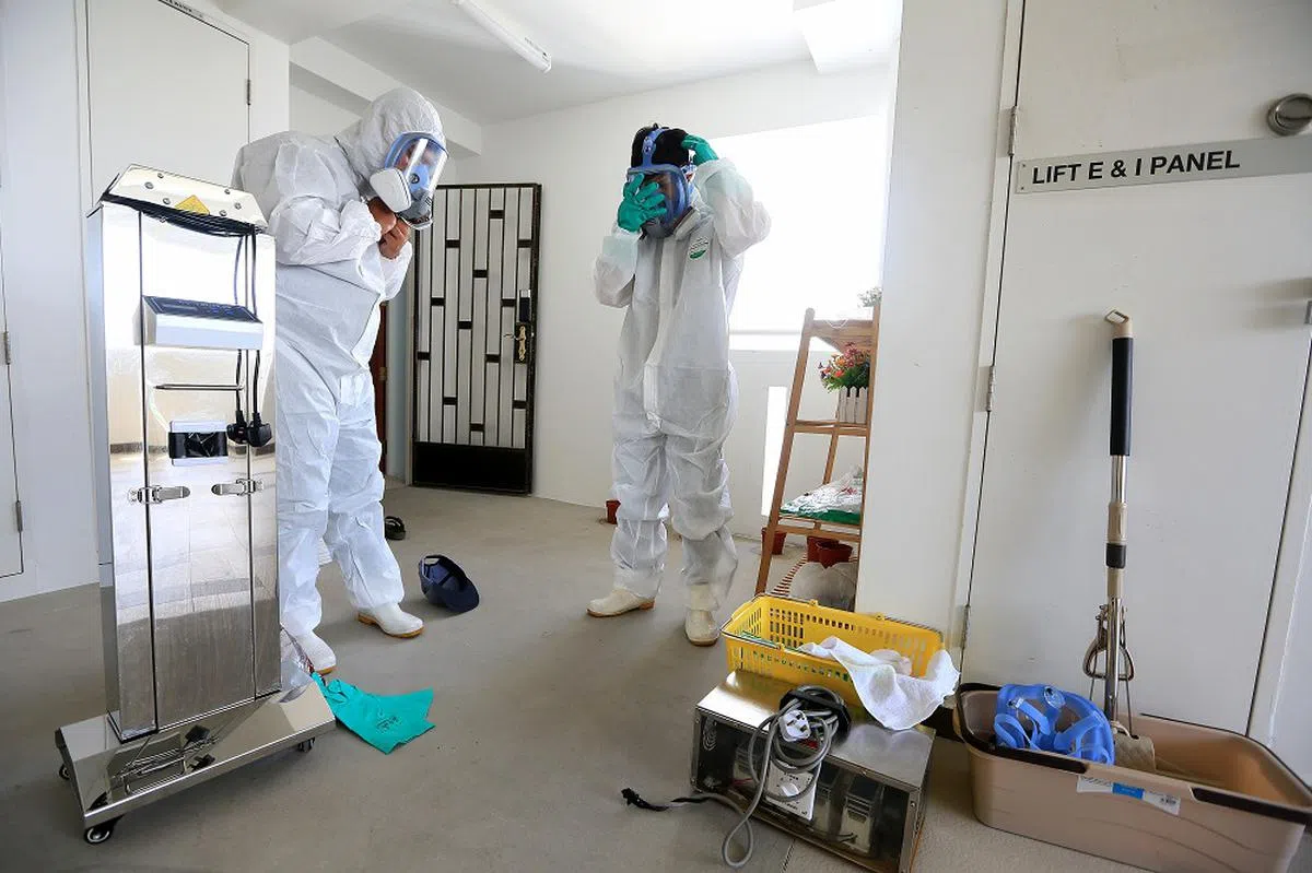 遗物整理师进入“孤独死”往生者住家处理遗物前必须全副武装，包括穿上防护衣，宛如抗疫的前线医务人员。（联合早报）