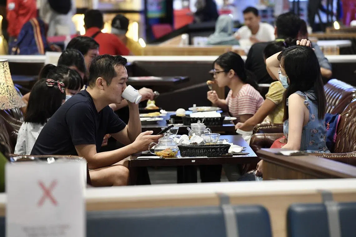 本地一家餐馆实施“喧哗孩童附加费”，引起一些食客不满。图为本地父母带孩子外出堂食。（海峡时报）