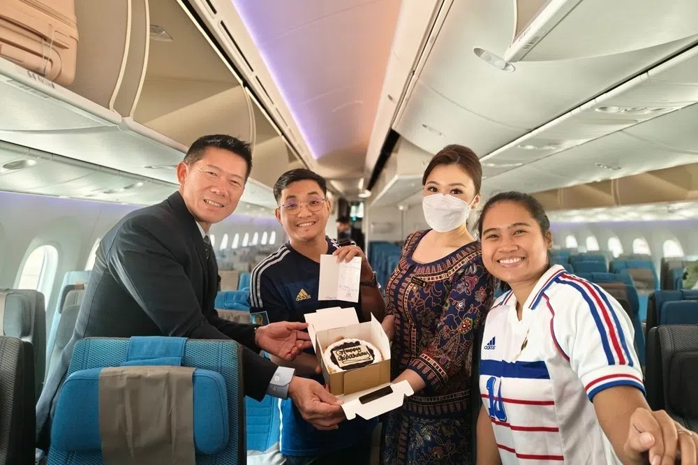 过生日的乘客与机组人员开心合影。