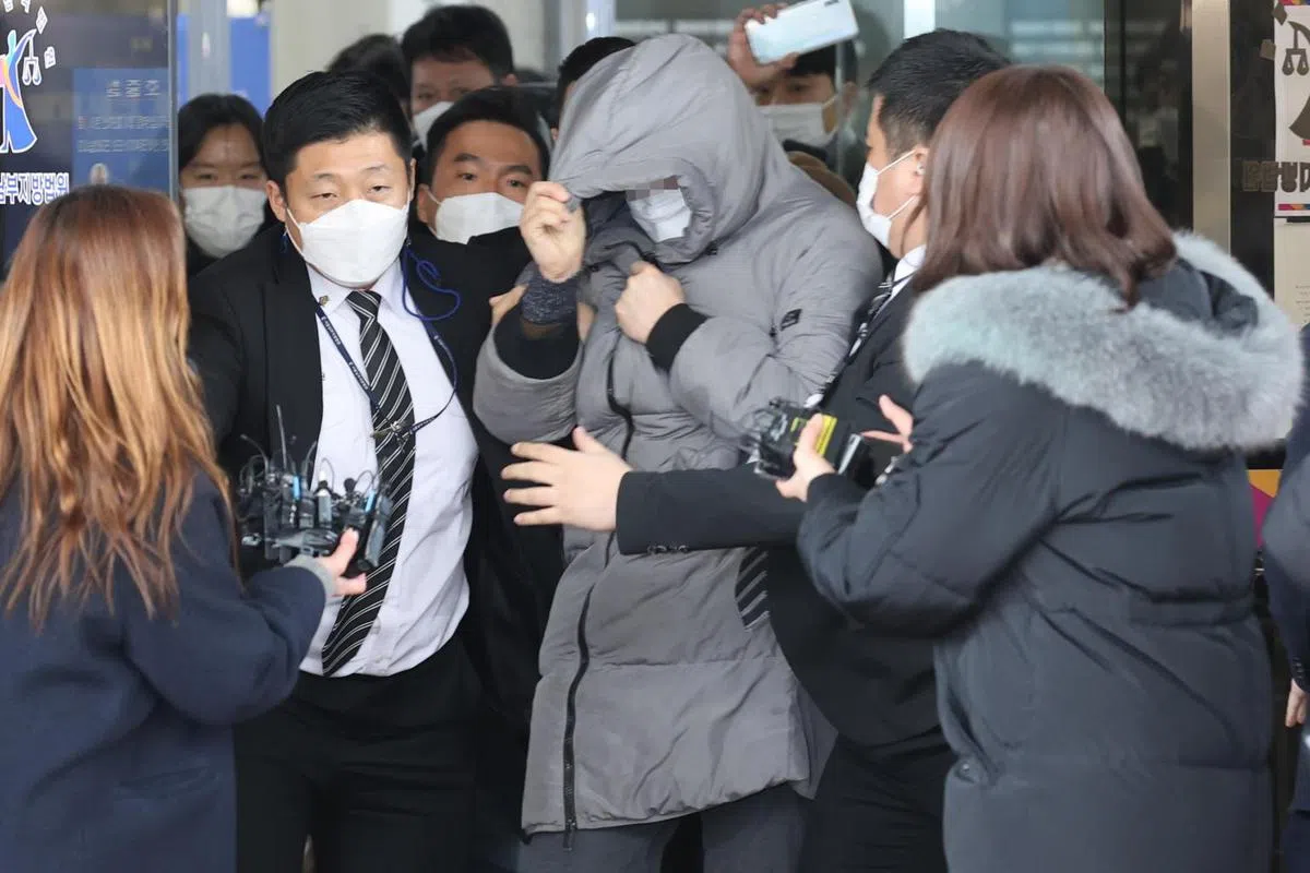 涉嫌虐待儿童和疏忽照顾安姓养父（中）离开法院时被当地记者团团包围。（韩联社） 