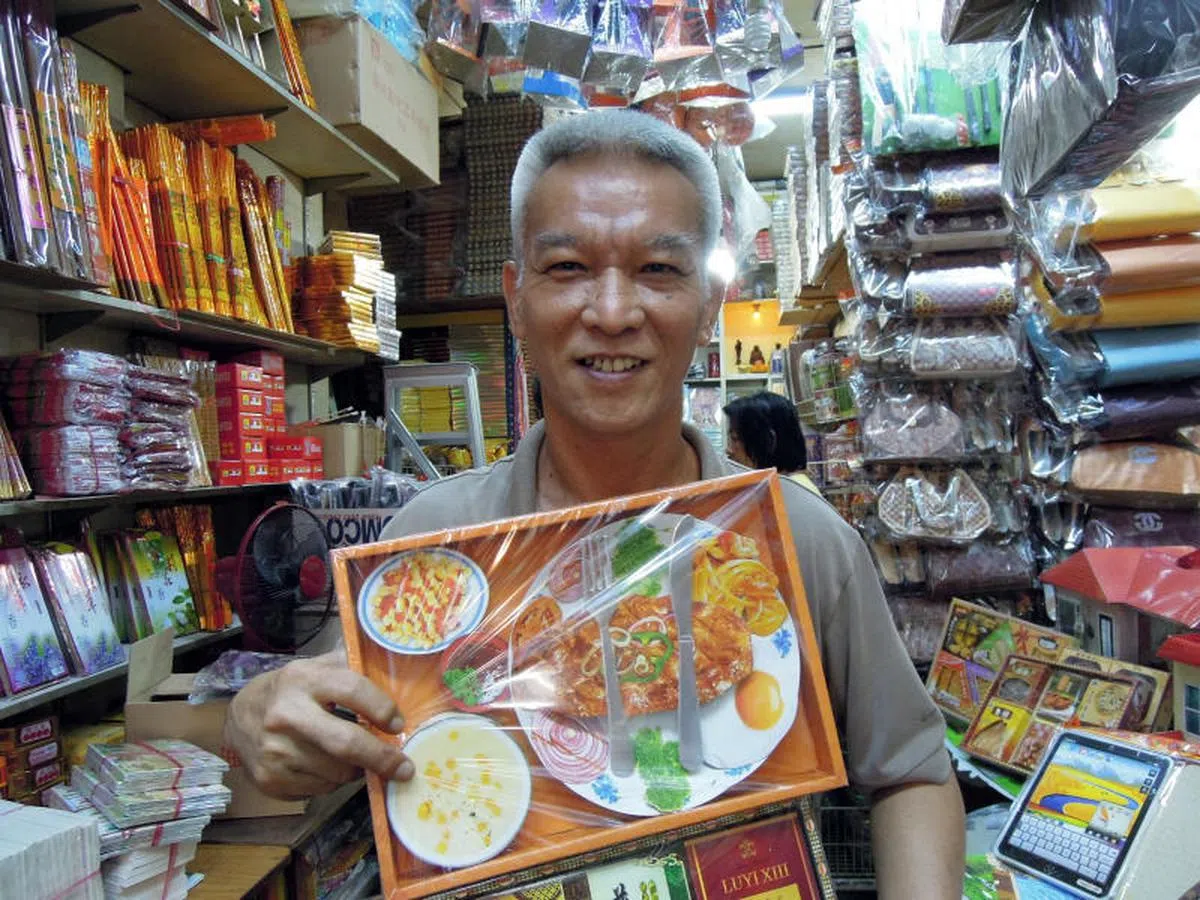  2012年，位于芽笼路的“一天香”神纸用品店负责人洪亚强展示的阴府牛排西餐。（联合晚报） 