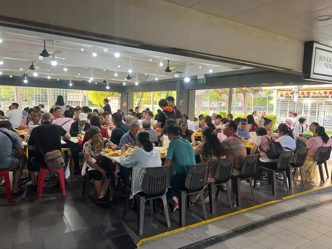 4月22日上午，数辆旅行车载了超过200名旅客，到惹兰勿刹地铁站附近的吉兰丹路组屋楼下咖啡店用早餐。（联合早报读者提供）