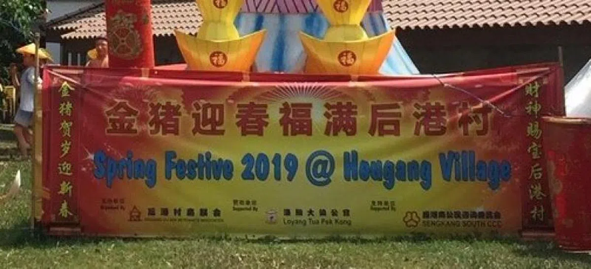  在财神爷脚下，写着主办方和支持单位的有关机构（黄纯仪摄） 