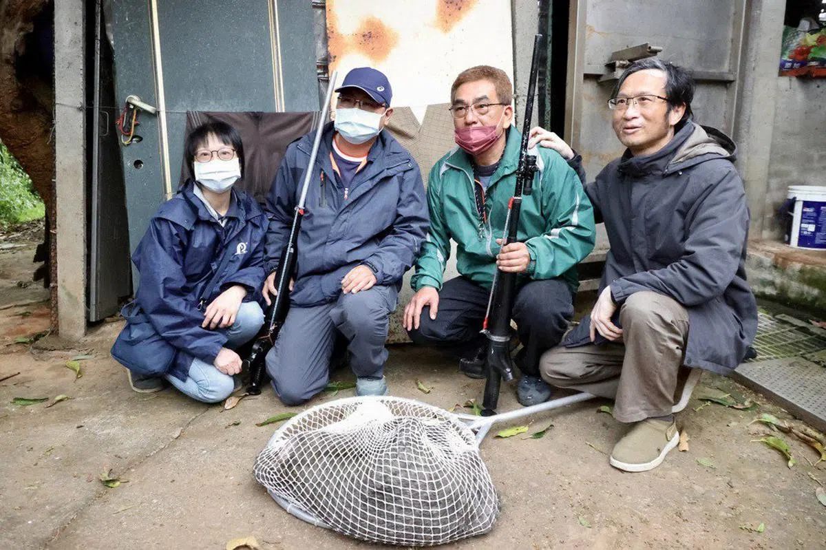 官员逮住狒狒后与狒狒合影。（联合报）