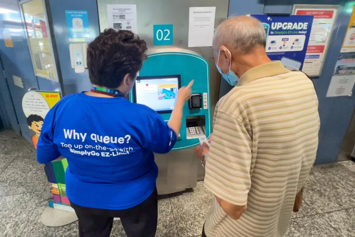 一名年长民众在向工作人员了解新易通卡的详情。（联合早报）