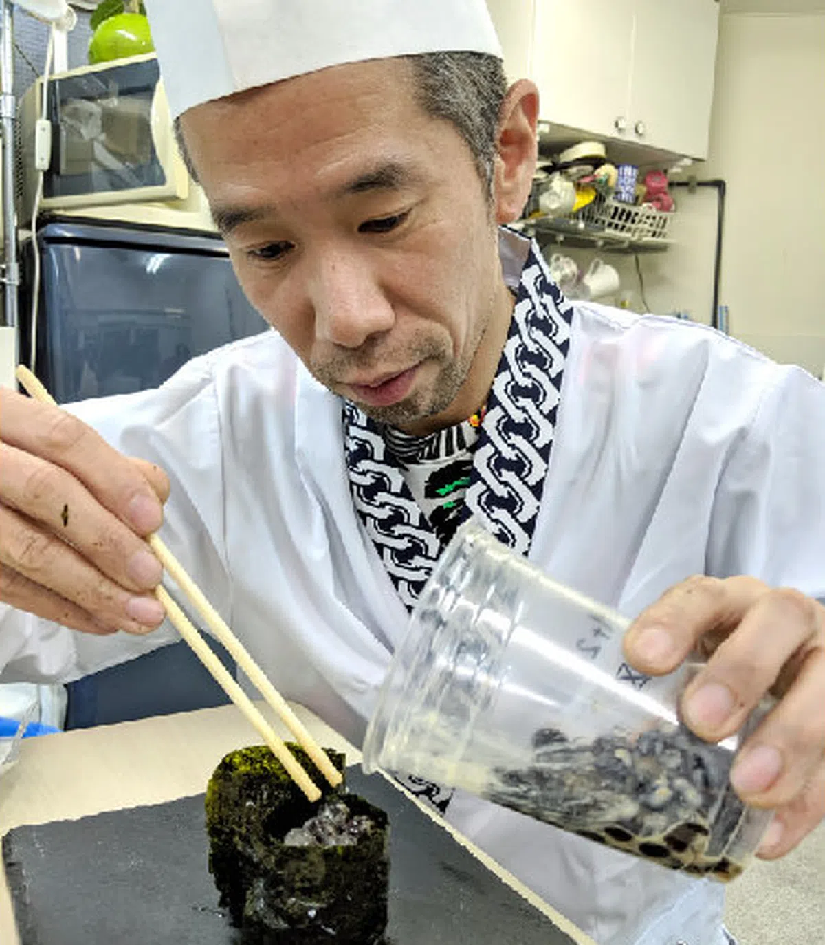  佐藤先生把珍珠倒入寿司上方的空位。（英国那些事儿微博） 
