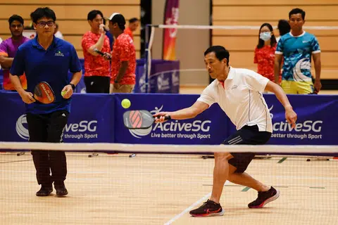 卫生部长王乙康（身穿白衣者）在去年10月尝试匹克球（pickleball）。（联合早报）