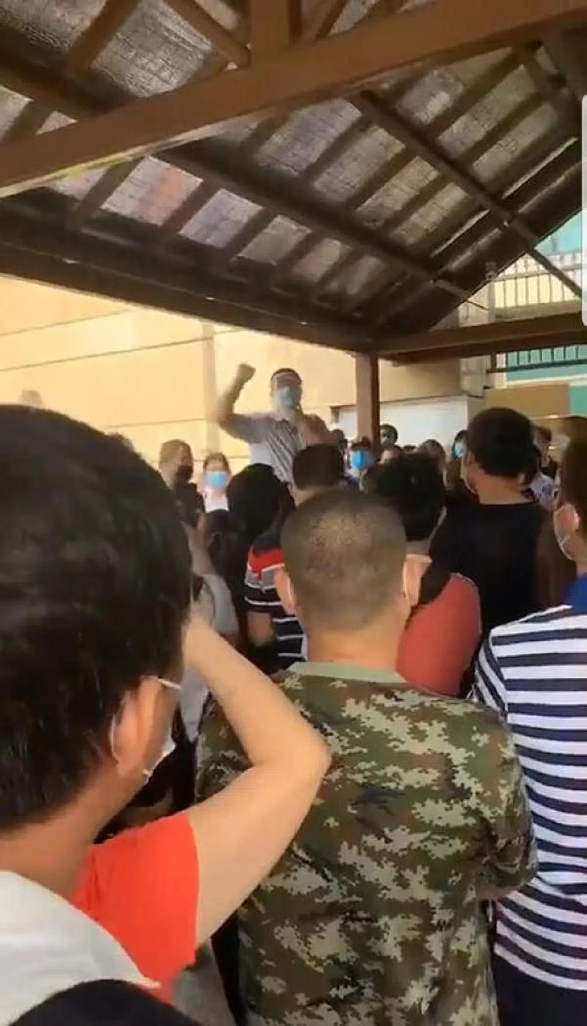 网上视频流传指不少中国公民到中国驻新加坡大使馆了解情况，后来工作人员到场向他们解释相关政策。（互联网） 