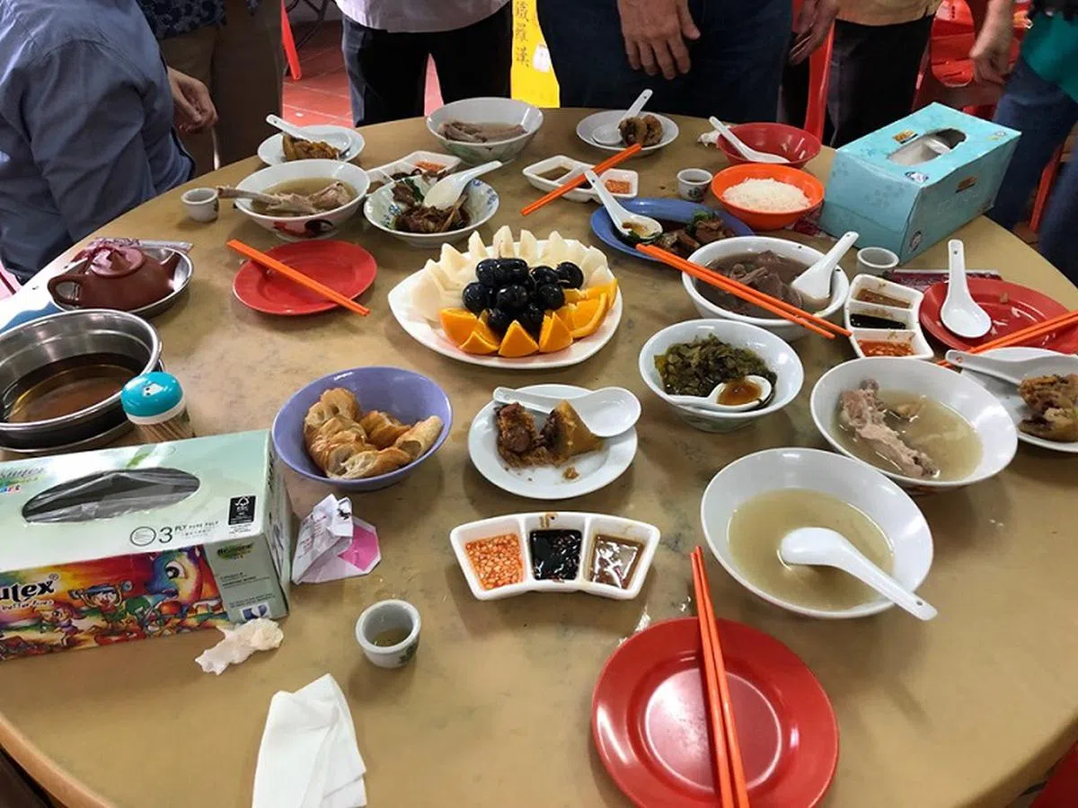  一行人所吃的早餐，还有“老字号中峇鲁肉骨茶”老板准备的水果拼盘和粽子。（侯佩瑜摄） 