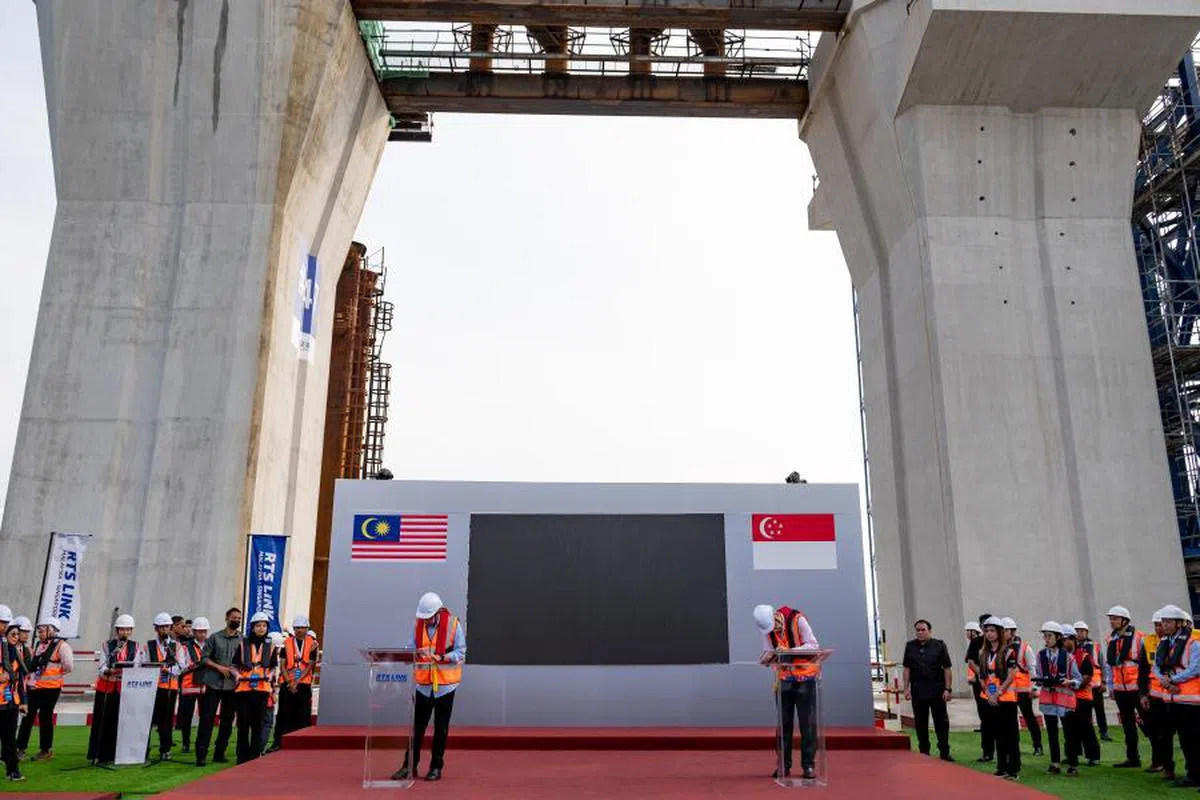 新加坡总理李显龙（右）和马国首相安华（左）日前见证新柔地铁高架轨道衔接的历史性时刻。（联合早报）