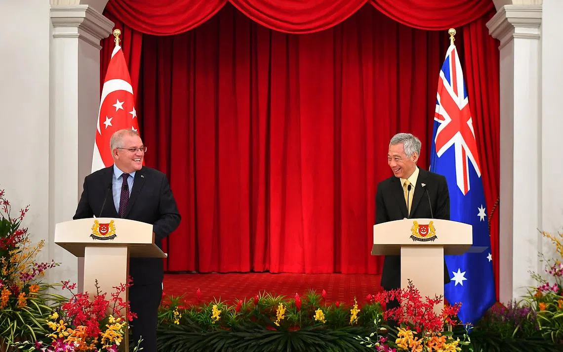 新加坡总理李显龙（右）与来访的澳洲总理莫里森2021年6月10日举行第六届新澳领袖级会议后，在总统府召开联合记者会。（海峡时报）