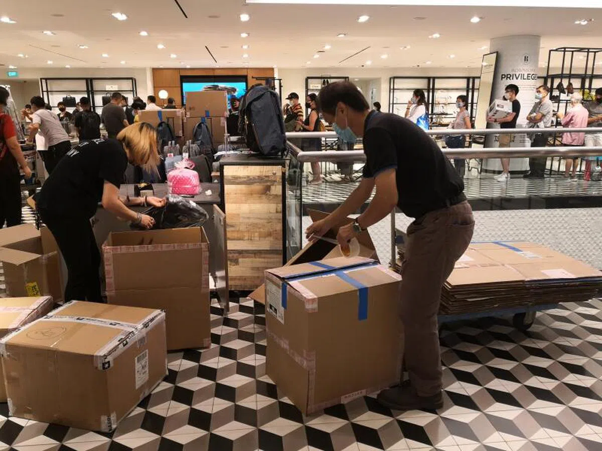  清盘消息宣布后，罗敏申员工清点货物，装入箱子运出。（联合早报） 
