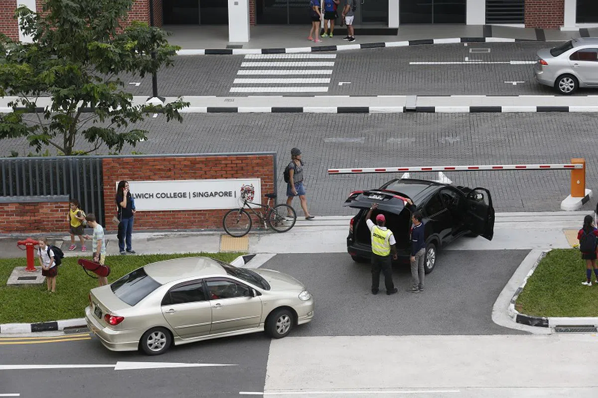  坐落于武吉巴督西的德威士学院（Dulwich College）新加坡分校的门口上下学时，总有家长开车来接送。（海峡时报） 
