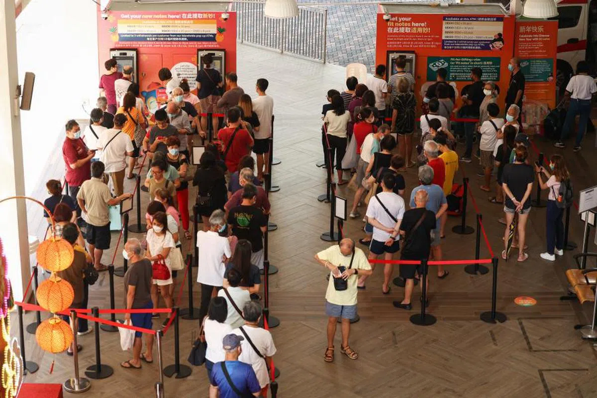 需要亲自到银行办理存款“解锁”，对部分年轻人而言可能是种不便。图为农历新年前夕到全岛各家银行换新钞的民众。（联合早报）